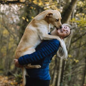 Dog kissing her laughing