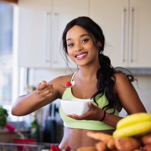 Black woman smiling eating fruit