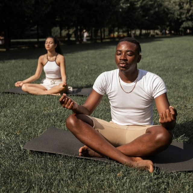 Couple meditating on grass