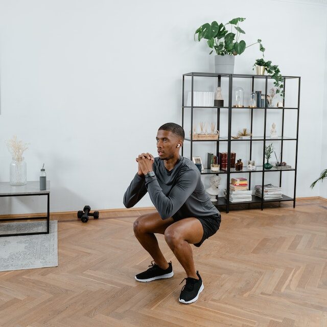 Man doing a squat no weights at home