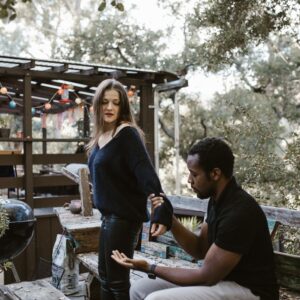 Man stopping woman from leaving him on a deck