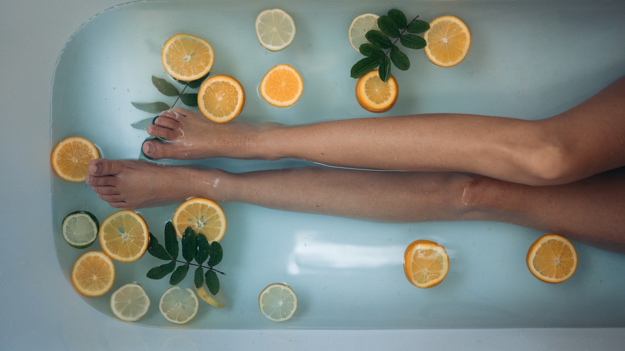 Legs of a Woman in a Tub with oranges
