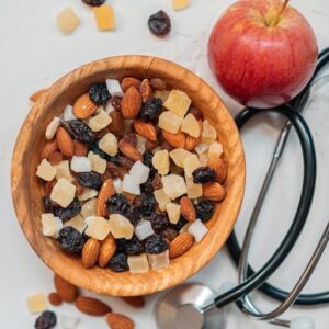 Nuts in a bowl with an apple and a stethoscope
