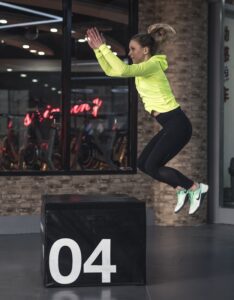 Woman jumping over crate crossfit