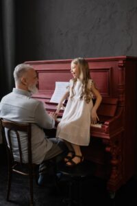 Grandpa playing piano with her granddaughter